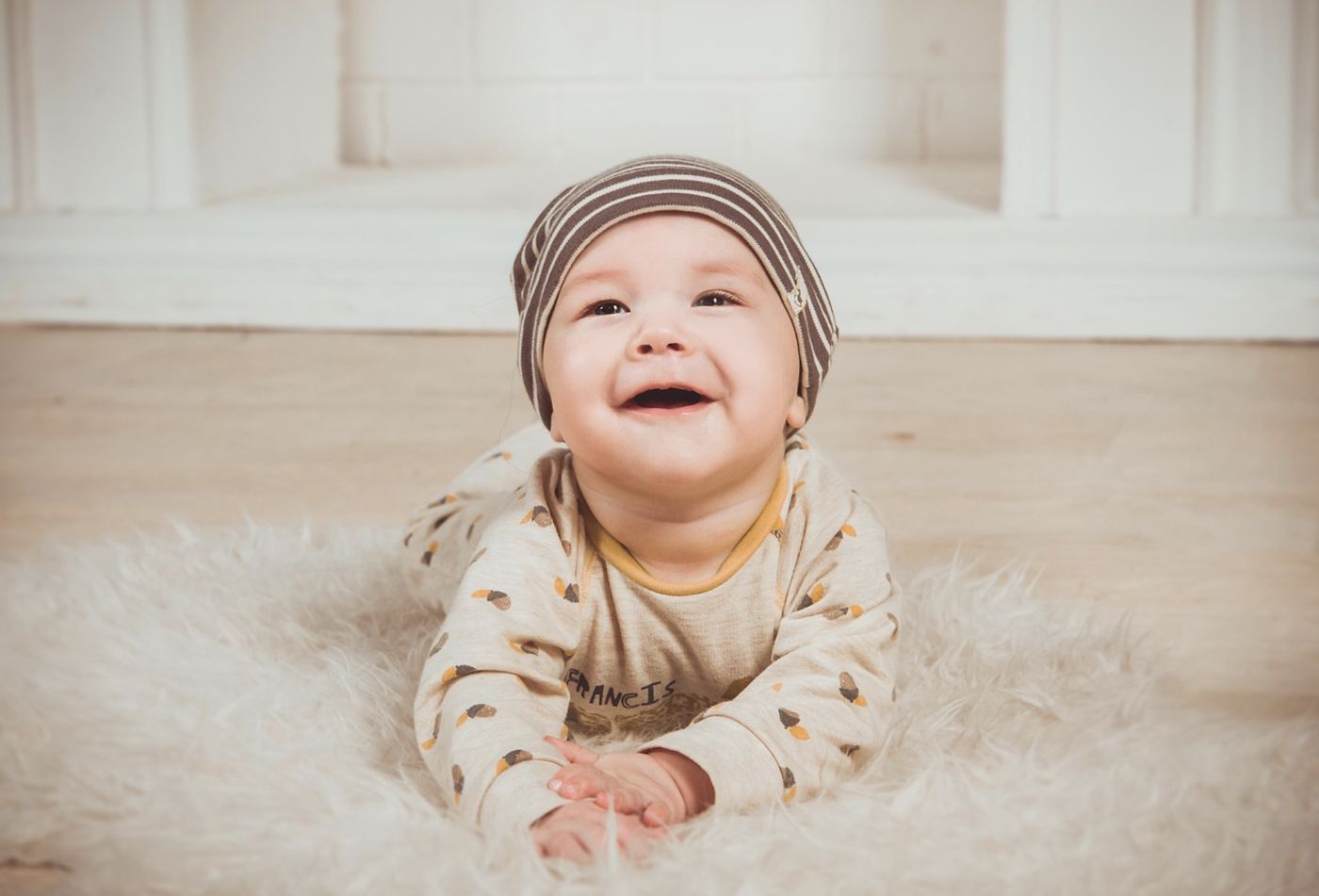 Happy baby on a rug looking up
